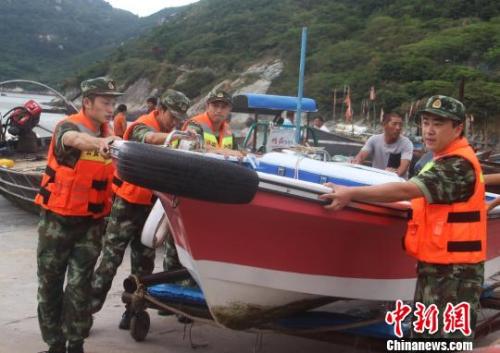 图为温州公安边防官兵帮民众转移船只。王华 摄 图为温州公安边防官兵帮民众转移船只。王华 摄