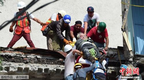 搜救人员将一位老人从废墟中救出。