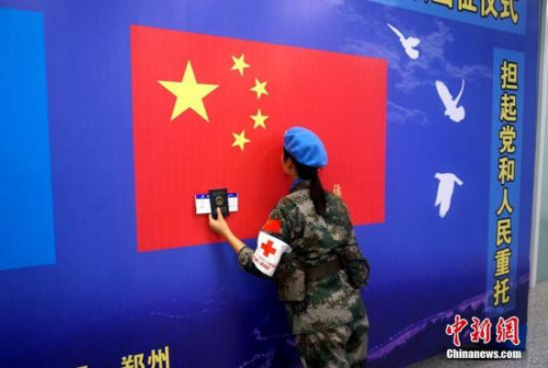 一名维和女兵出征前亲吻五星红旗。 李志全 摄 一名维和女兵出征前亲吻五星红旗。 李志全 摄