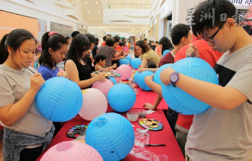 数十名孩子及家长透过手中的画笔及彩色盘，让平凡无奇的传统灯笼增添色彩。（马来西亚《星洲日报》）