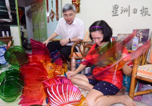 董顺颜的家人戚亚兰(右)向马袖强展示玻璃纸灯笼制作过程。(马来西亚《星洲日报》) 董顺颜的家人戚亚兰(右)向马袖强展示玻璃纸灯笼制作过程。(马来西亚《星洲日报》)