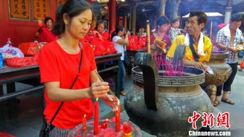 图为信众在虔诚为拜谒活动点香。 郭斌 摄 图为信众在虔诚为拜谒活动点香。 郭斌 摄