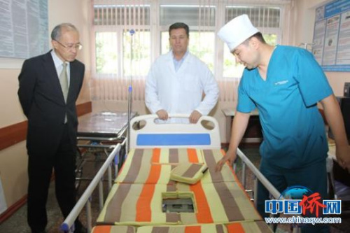 中国驻吉尔吉斯斯坦奥什总领事馆总领事宋利群(左)了解奥什州医院多功能床的使用情况。　陶拴科 摄