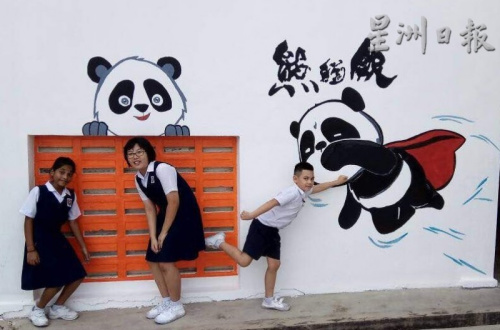 学生喜爱在壁画前拍照留念。(马来西亚《星洲日报》) 学生喜爱在壁画前拍照留念。(马来西亚《星洲日报》)