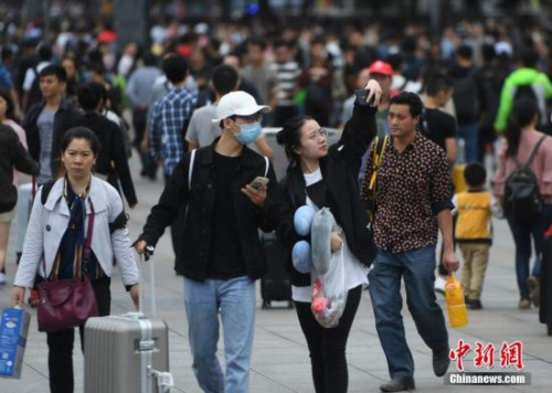 9月30日，全国多地迎来国庆假期客流高峰。图为重庆旅客在火车站广场上玩自拍。 <a target='_blank' href='http://www.chinanews.com/'>中新社</a>记者 陈超 摄