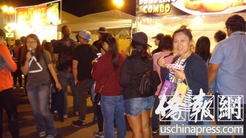 圣盖博教会路饺子摊亭一个挨一个,每个摊亭前都大排长龙,圣盖博居民邓晓玲女士(右二)一边吃饺子一边排队。(侨报记者高睿摄) 圣盖博教会路饺子摊亭一个挨一个,每个摊亭前都大排长龙,圣盖博居民邓晓玲女士(右二)一边吃饺子一边排队。(侨报记者高睿摄)