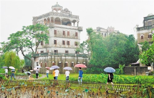 尽管天下着小雨，游客仍冒雨参观开平自力村碉楼。伍安平 摄