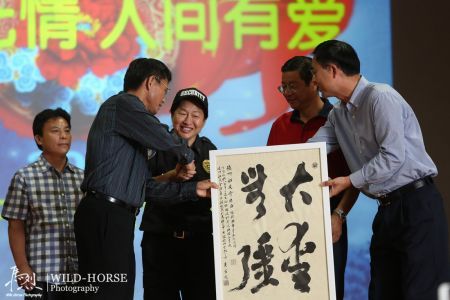 图左一：黄鑫，书法家，休斯顿华星艺术团理事，“华星书院”院长，东方艺术教育中心“茶书园”会长。北京大学学士，中国科学院硕士，多伦多大学博士。为赈灾义演挥毫《大爱无疆》，图右一：休斯敦华星艺术团副团长徐华。(照片来自微博 未名空间)