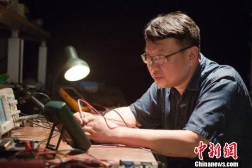 邓建军在维修设备。 江苏常州黑牡丹(集团)股份有限公司供图。 邓建军在维修设备。 江苏常州黑牡丹(集团)股份有限公司供图。