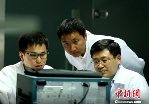 图为，中国工程院院士、浪潮集团首席科学家王恩东(右一)与团队成员进行研发。资料图