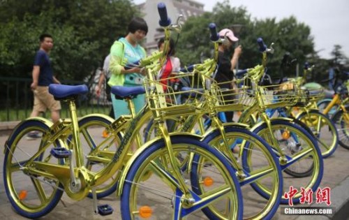2017年6月8日，民众在北京街头扫码租用一款“土豪金”色的酷骑共享单车。 <a target='_blank' href='http://www.chinanews.com/'>中新社</a>记者 杨可佳 摄