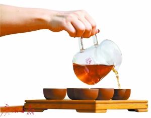 茶艺师倒出茶水。 茶艺师倒出茶水。