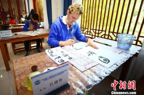 图为营员体验东巴字画。 王崴 摄 图为营员体验东巴字画。 王崴 摄
