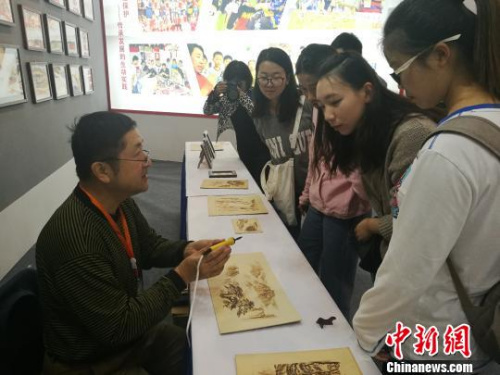 刘凯的弟子时联峰向参观的学生介绍“火笔” 刘浩 摄