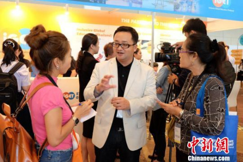 展台工作人员认真解答学生及家长的问题。 赵婧楠 摄 展台工作人员认真解答学生及家长的问题。 赵婧楠 摄