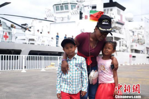 11月14日，在马普托港码头，一名莫桑比克妇女带着两个孩子送别和平方舟医院船。　江山 摄
