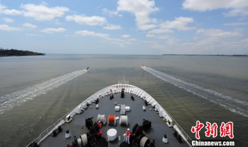 中国海军和平方舟医院船缓缓驶离马普托港时，当地民众、华侨华人自发驾驶小艇引航，送别和平方舟。　江山 摄