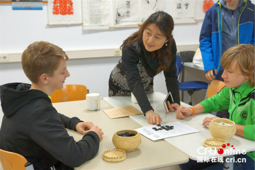 杨爽指导德国中学生下棋。 杨爽指导德国中学生下棋。