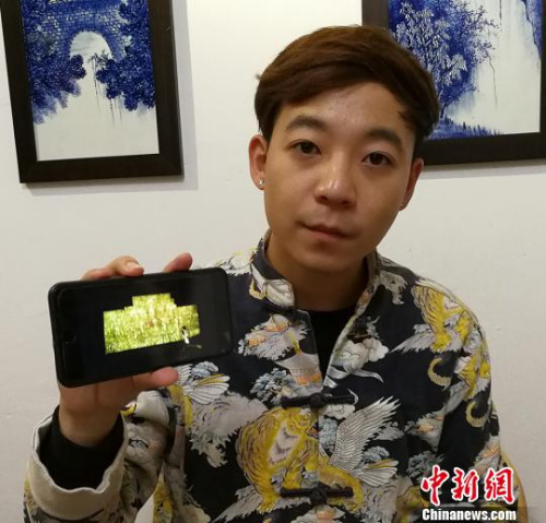 闫鑫向记者展示《药师经变》壁画在广胜寺内墙壁上的数字影像。 杨杰英 摄 闫鑫向记者展示《药师经变》壁画在广胜寺内墙壁上的数字影像。 杨杰英 摄