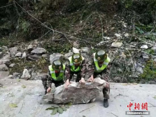 图为部队官兵清理道路巨石。武警交通部队供图