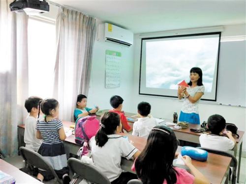 陈小清给学生上剪纸课。 陈小清给学生上剪纸课。