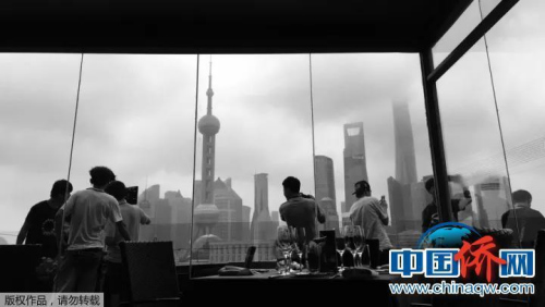“手机摄”上海外滩罗斯福色戒餐厅，大家透过窗户在拍摄清晨的东方明珠。