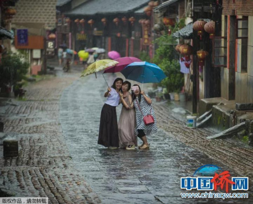“相机摄”湖南永州市零陵老街，三位美女在雨中的老街玩自拍。