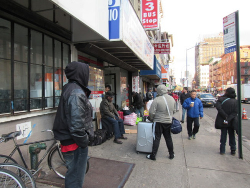 巴士站门口也站着许多提着行李候车的民众。(美国《世界日报》/颜嘉莹 摄)