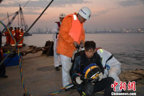 现场救助人员商讨下水营救方案 康乐 摄