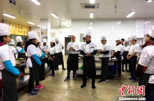 图为扬州厨师向马来华裔少年讲授扬州炒饭制作。　王爱萍 摄