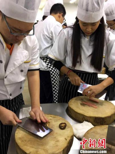图为马来华裔少年学做扬州炒饭。　王爱萍 摄