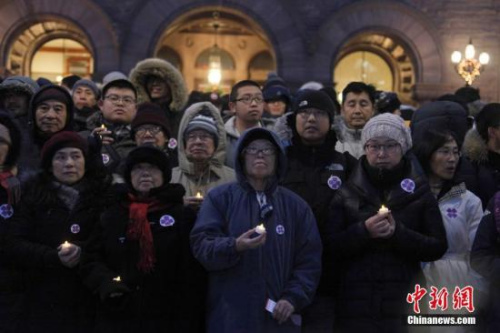 在南京大屠杀80周年之际，当地时间12月13日，加拿大安大略省省议会举行南京大屠杀纪念活动。图为来自华人社区及其他多族裔社区的数百人当晚冒着严寒聚集在安省议会大楼前，举行烛光追思会。<a target='_blank' href='http://www.chinanews.com/'>中新社</a>记者 余瑞冬 摄