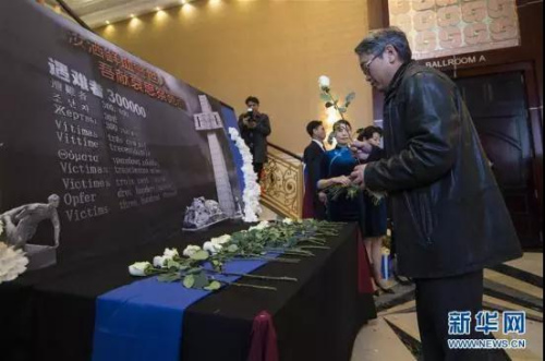 一名男子在纪念南京大屠杀80周年追思会上献花 一名男子在纪念南京大屠杀80周年追思会上献花