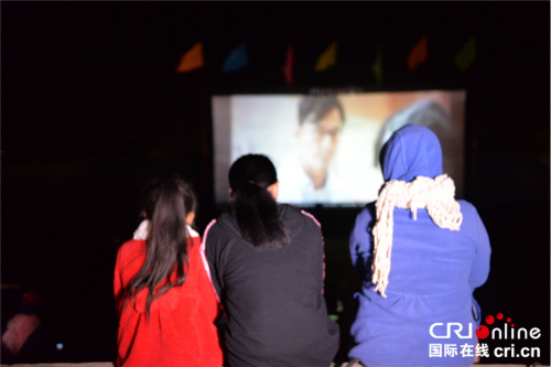 川圹省民众在寒冷天气中观看露天电影。