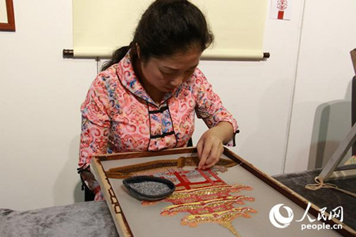 潮汕刺绣项目传承人洪裕静借鉴了双面绣技法，正在进行双面珠绣的创作。(摄影：吴玉洁)