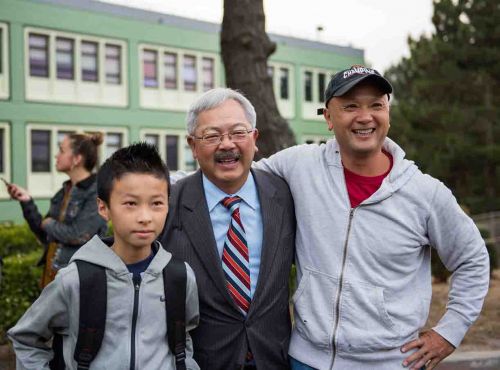 李孟贤(中)视察旧金山学区访谷中学时与学生及家长合影。(图片来源：市长办公室提供)