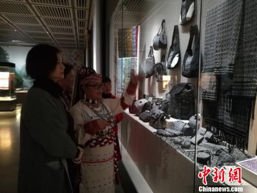 图为连美惠向昆明市民介绍“壮太同纹锦”。 胡远航 摄 图为连美惠向昆明市民介绍“壮太同纹锦”。 胡远航 摄