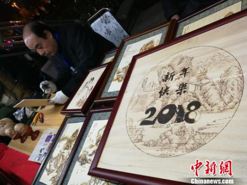 图为非遗传承人在制作烙画。 董飞 摄 图为非遗传承人在制作烙画。 董飞 摄