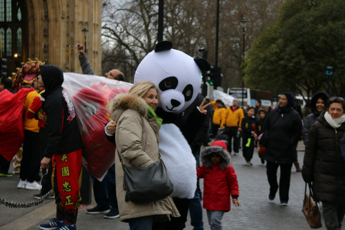 熊猫团队在队伍最后，向沿途观众派发纪念品，送上新年的祝福。 