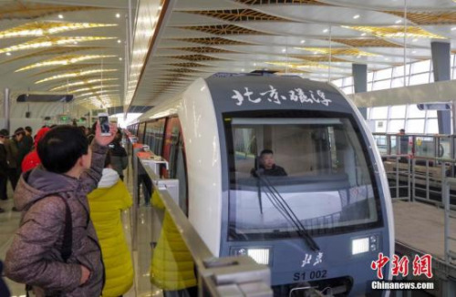 12月30日，北京首条磁悬浮轨道交通S1线开通试运营，乘客为列车拍照留念。北京S1线磁浮列车全长89.6米、宽3米、高3.7米，设计时速100公里，最大载客量1032人。从2011年开工建设至2017年10月完工。<a target='_blank' href='http://www.chinanews.com/'>中新社</a>记者 贾天勇 摄