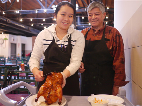 毕业于专业餐饮学院的小女儿郑文彩(左)，在父亲郑兆章(右)指导下，片鸭功力了得。(特派员黄惠玲／摄)