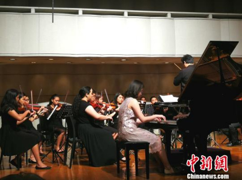 当天两个小时的演出里,吴氏姐妹轮流登场,独奏两轮后,又分别与马尼拉交响乐团合作。这是妹妹吴珮玲在演奏。 关向东 摄 当天两个小时的演出里,吴氏姐妹轮流登场,独奏两轮后,又分别与马尼拉交响乐团合作。这是妹妹吴珮玲在演奏。 关向东 摄