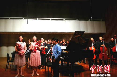 现场多位音乐人表示，姐妹俩十几岁即与交响乐团合作开音乐会，台风稳健，颇具天分，全菲少见。这是演出结束，观众献花祝贺。　关向东 摄