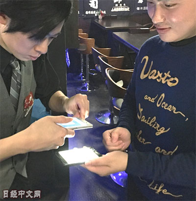 店员用设备读取显示的条码,即可完成结算。(日经中文网) 店员用设备读取显示的条码,即可完成结算。(日经中文网)