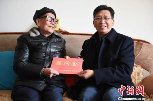图为重庆市人民政府外事侨务办公室党组书记、主任吴康明向南侨机工蒋印生送上慰问金。 周毅 摄 图为重庆市人民政府外事侨务办公室党组书记、主任吴康明向南侨机工蒋印生送上慰问金。 周毅 摄