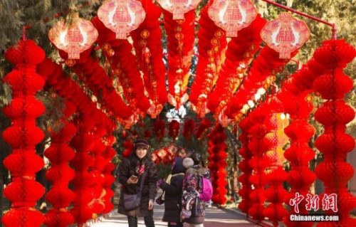 资料图:2018年2月2日,北京地坛公园,市民经过挂满红灯笼的通道。随着农历春节的临近,北京城年味渐浓。<a target='_blank' href='http://www.chinanews.com/'>中新社</a>记者 侯宇 摄 资料图:2018年2月2日,北京地坛公园,市民经过挂满红灯笼的通道。随着农历春节的临近,北京城年味渐浓。<a target='_blank' href='http://www.chinanews.com/'>中新社</a>记者 侯宇 摄
