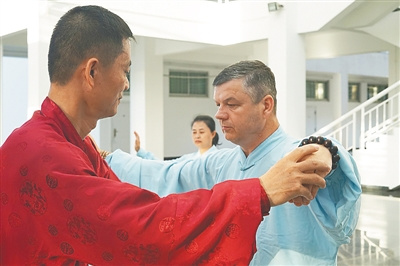 林方卿(左一)指导谢志明学习太极拳。