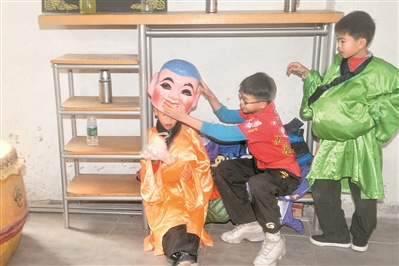 学习了一个上午的大头佛表演,小学徒在一旁休息。 学习了一个上午的大头佛表演,小学徒在一旁休息。
