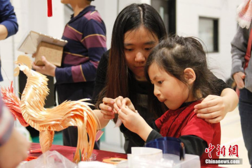 图为一位来自中国的受领养女孩跟在志愿者帮助下学习编织彩色纸带。 <a target='_blank' href='http://www.chinanews.com/'>中新社</a>记者 余瑞冬 摄