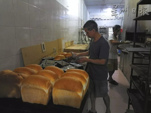 王氏兄弟每天在面包店里忙忙碌碌,为顾客烘焙出新鲜面包。(马来西亚《星洲日报》记者/李慧婷 摄) 王氏兄弟每天在面包店里忙忙碌碌,为顾客烘焙出新鲜面包。(马来西亚《星洲日报》记者/李慧婷 摄)